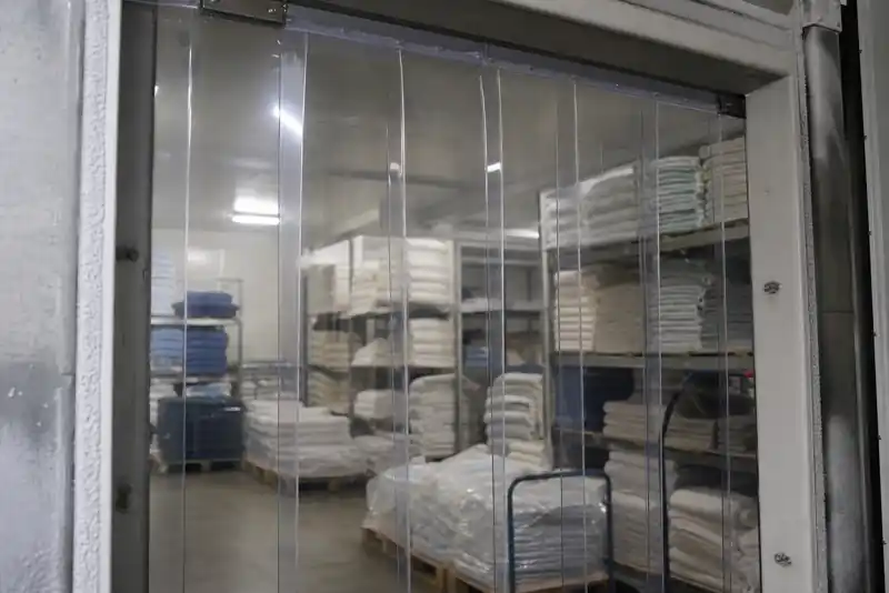 Polar-grade PVC strip curtain flaps at a temperature-controlled textile storage doorway